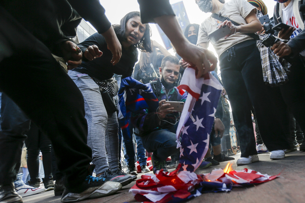 FILE - People burn an American flag in Los Angeles, Saturday, Nov. 7, 2020. (AP Photo/Ringo H.W. Chiu, File)