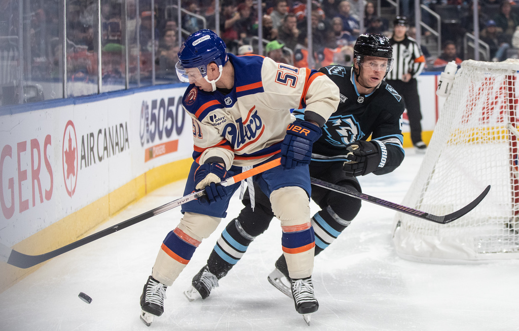 Utah Mammoth's Olli Maatta (right) and Edmonton Oilers' Troy Stecher (51) battle for the puck during first period NHL action, in Edmonton on Tuesday, October 28, 2025. (Jason Franson/The Canadian Press via AP)
