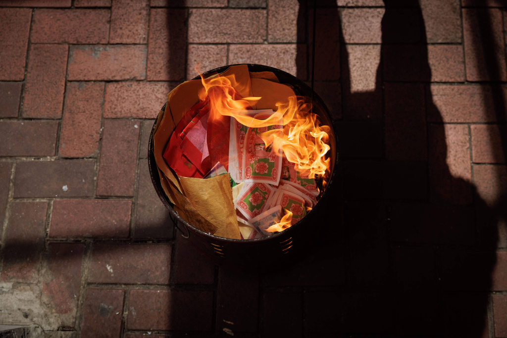 Joss paper burns in a metal bin ahead of the Lunar New Year in Hong Kong, Feb. 11, 2026. (AP Photo/May James)