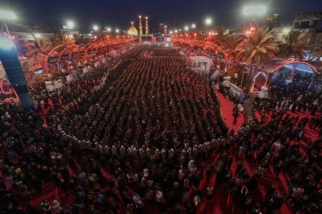 Shiite faithful worshippers gather between the holy shrines of Imam Hussein and Imam Abbas, seen in the background, during "Muharram," a period of mourning for Shiites in Karbala, Iraq, Wednesday, June 24, 2025. (AP Photo/Hadi Mizban)