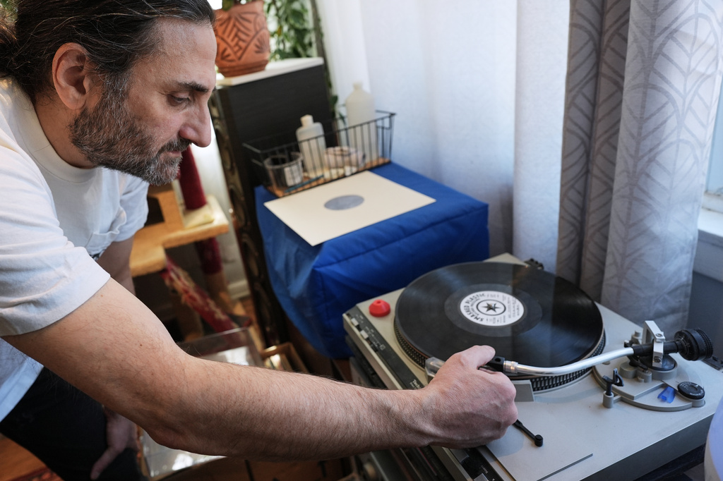 Aadam Jacobs plays a LP (long play) record at his home in Chicago, Thursday, March 19, 2026. (AP Photo/Nam Y. Huh)