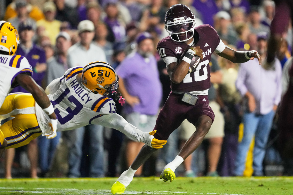 Texas A&M quarterback Marcel Reed (10) carries for a touchdown against LSU defensive back A.J. Haulcy (13) in the first half of an NCAA college football game, Saturday, Oct. 25, 2025 in Baton Rouge, La. (AP Photo/Gerald Herbert)