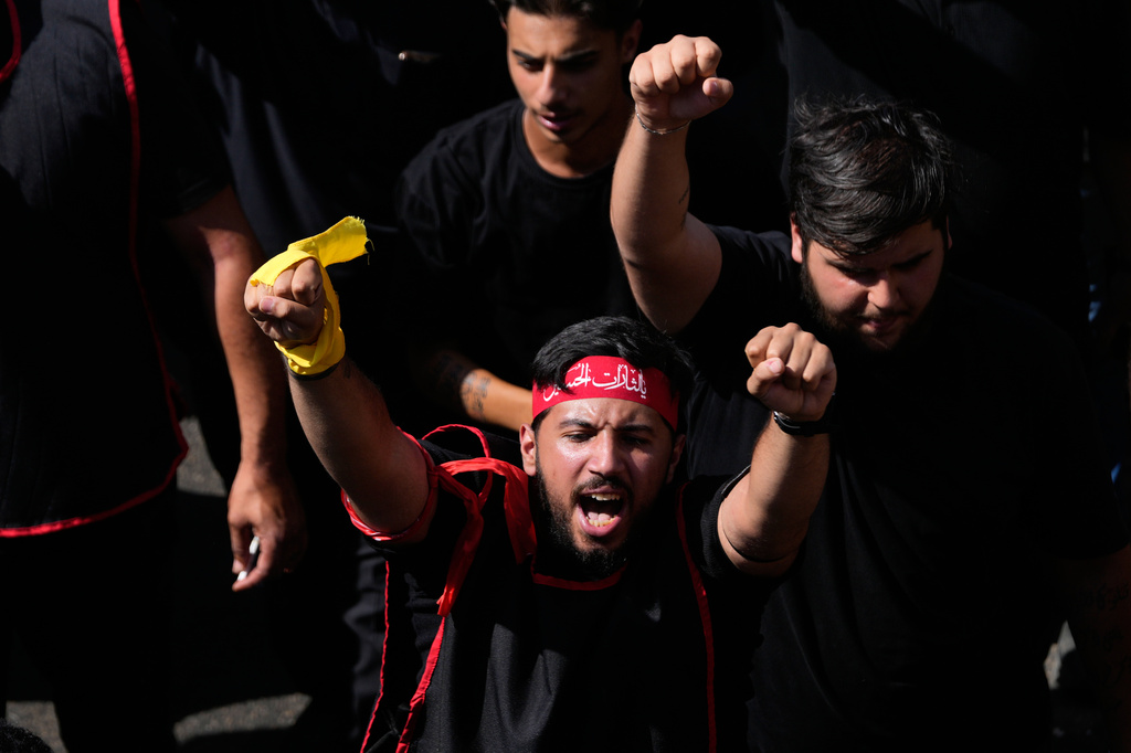 A Hezbollah supporter shouts slogans, as he marches during the holy day of Ashoura that commemorates the 7th century martyrdom of the Prophet Muhammad's grandson Hussein, in Dahiyeh, Beirut's southern suburbs, Lebanon, Friday, June 26, 2026. (AP Photo/Hussein Malla)
