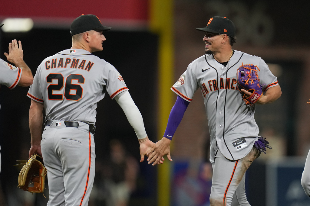San Francisco Giants shortstop Willy Adames, right, celebrates with teammate third baseman Matt Chapman (26) after the Giants defeated the San Diego Padres 9-3 in a baseball game Tuesday, March 31, 2026, in San Diego. (AP Photo/Gregory Bull)