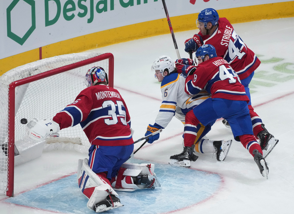 Buffalo Sabres' Zach Benson (6) scores against Montreal Canadiens goaltender Samuel Montembeault (35) as Canadiens' Lane Hutson (48) and Jayden Struble (47) try to defend during second-period NHL hockey game action in Montreal, Thursday, Jan. 22, 2026. (Christinne Muschi/The Canadian Press via AP)