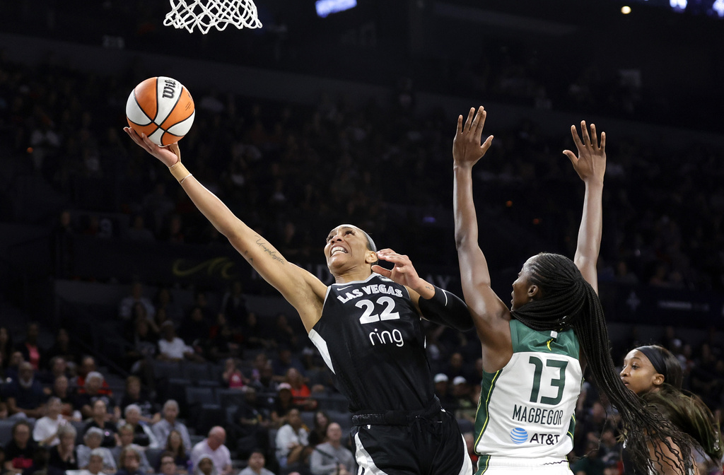 Las Vegas Aces center A'ja Wilson (22) shoots a layup against Seattle Storm forward Ezi Magbegor (13) during the first half of a WNBA basketball game Friday, Aug. 8, 2025, in Las Vegas. (Steve Marcus/Las Vegas Sun via AP)