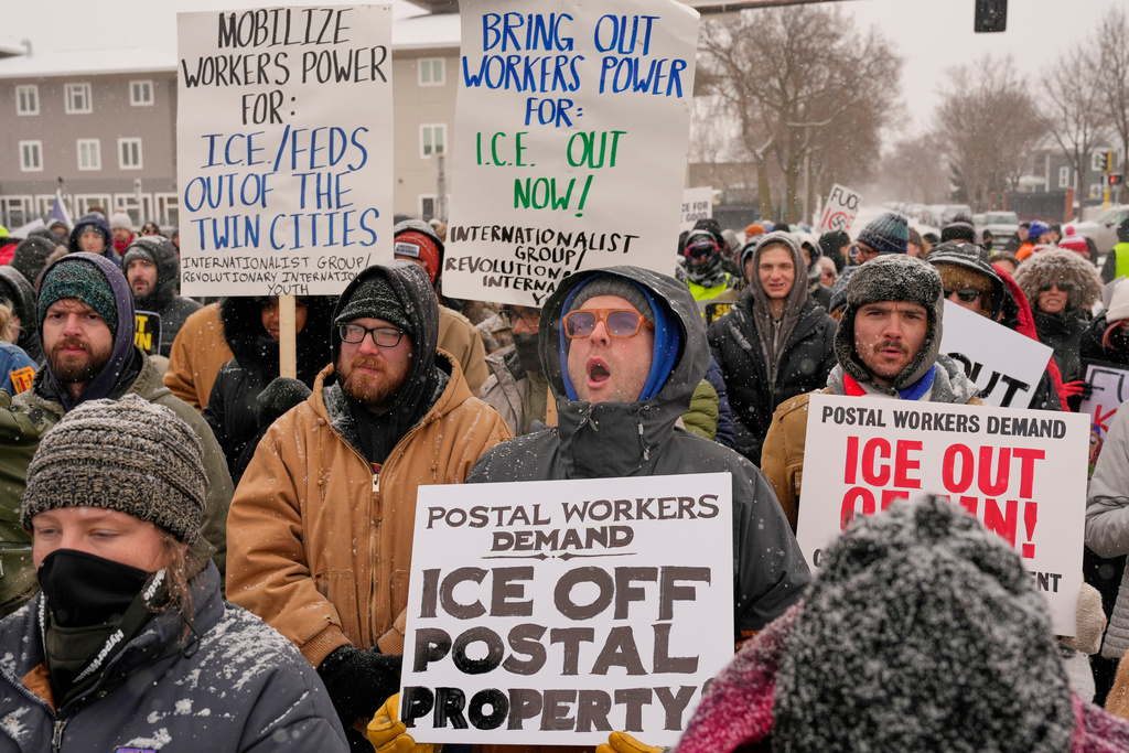 People march and gather near the post office during a protest, Sunday, Jan. 18, 2026, in Minneapolis. (AP Photo/Yuki Iwamura)