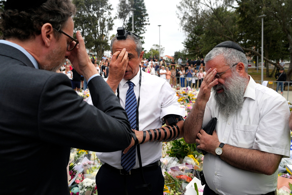 Israeli Ambassador to Australia Amir Maimon, center, prays at a floral memorial near the Bondi Pavilion at Bondi Beach on Tuesday, Dec. 16, 2025, following Sunday's shooting in Sydney, Australia. (AP Photo/Mark Baker)