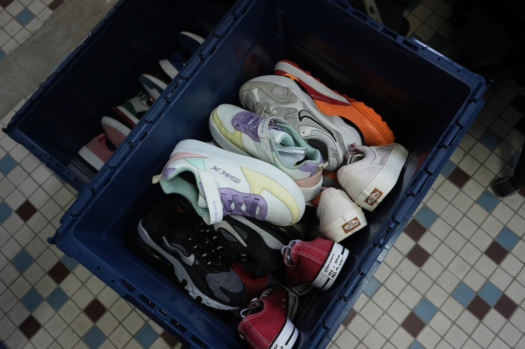 Salvaged sneakers for resale are stored in a bin at SneakCoeurZ, a nonprofit organization giving used footwear a second life, in Champs-sur-Marne, east of Paris, Wednesday, March 25, 2026. (AP Photo/Thibault Camus)