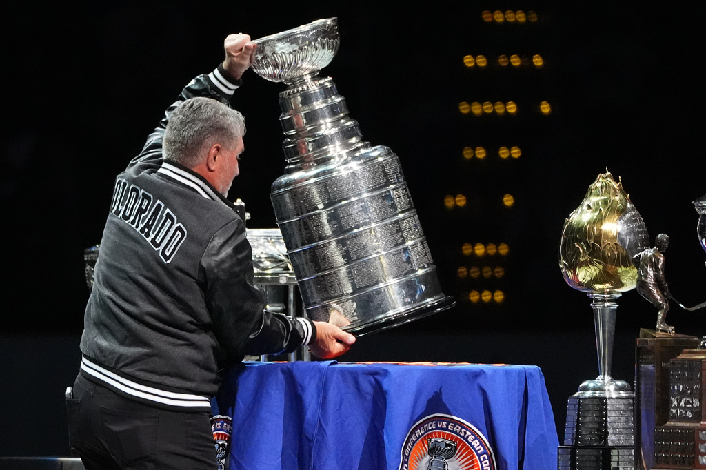 FILE - Retired NHL player Ray Bourque places the Stanley Cup on a table during a ceremony to honor members of the Colorado Avalanche's 2001 championship team that featured Bourque before an NHL hockey game against the Philadelphia Flyers, Jan. 23, 2026, in Denver. (AP Photo/David Zalubowski, File)