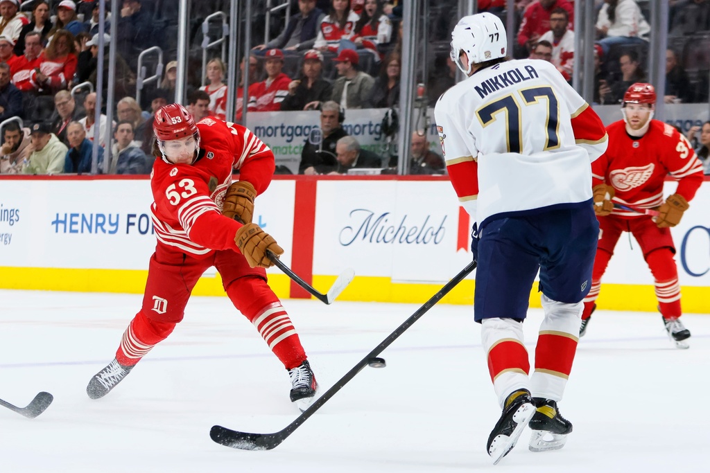 Detroit Red Wings defenseman Moritz Seider (53) shoots on goal against Florida Panthers defenseman Niko Mikkola (77) during the first period of an NHL hockey game Friday, March 6, 2026, in Detroit. (AP Photo/Duane Burleson)