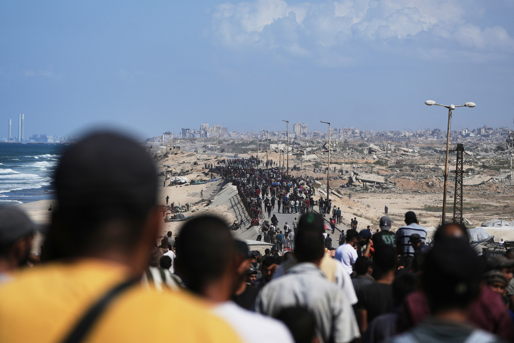 Displaced Palestinians walk along the coastal road near Wadi Gaza in the central Gaza Strip, moving toward northern Gaza, Friday, Oct. 10, 2025, after Israel and Hamas have agreed to a pause in their war and the release of the remaining hostages. (AP Photo/Abdel Kareem Hana)