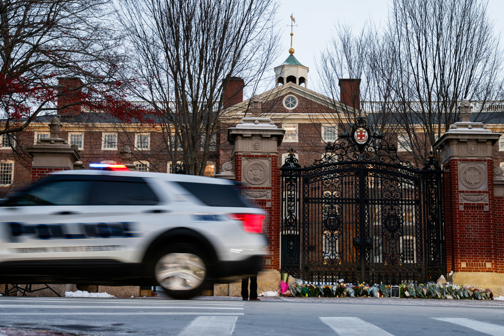 A Providence police car passes by Brown University's Van Wickle gates, in Providence, R.I., two days after a shooting took place on Brown University's campus, Monday, Dec. 15, 2025. (Lily Speredelozzi/The Sun Chronicle via AP)