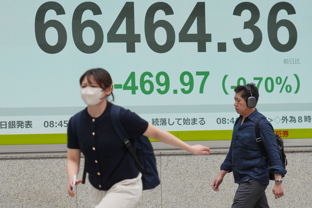 People walk in front of an electronic stock board showing Japan's Nikkei index at a securities firm Tuesday, June 2, 2026, in Tokyo. (AP Photo/Eugene Hoshiko)