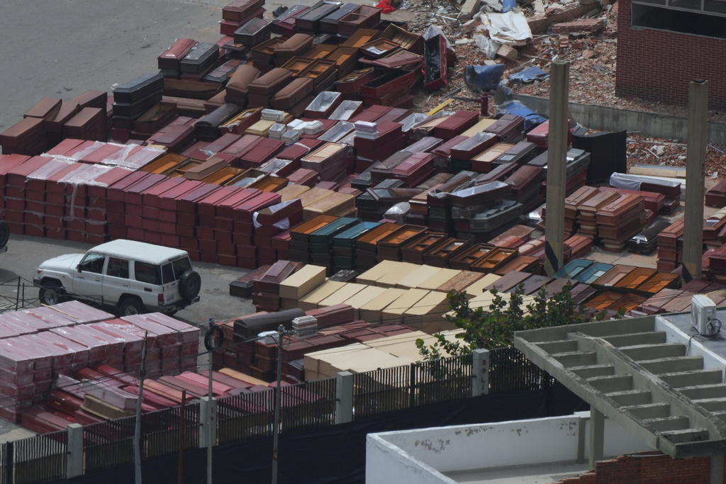 Coffins are stacked at the seaport where forensic workers sort the bodies of earthquake victims in La Guaira, Venezuela, Saturday, July 4, 2026. (AP Photo/Ariana Cubillos)