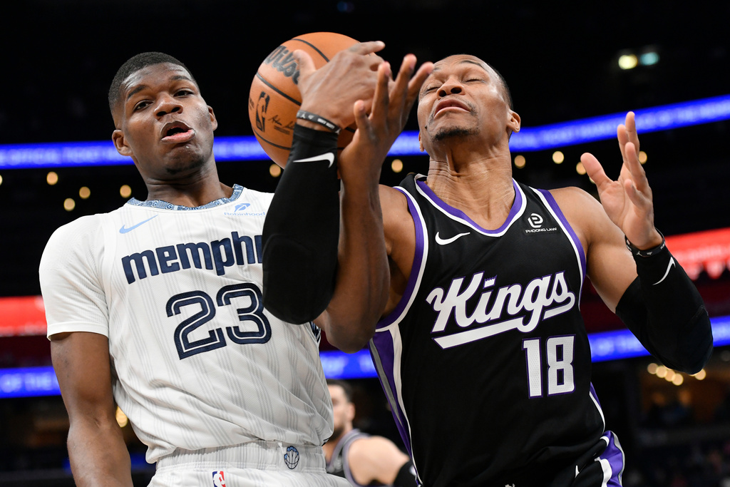 Memphis Grizzlies forward Cedric Coward (23) and Sacramento Kings guard Russell Westbrook (18) battle for control of the ball in the first half of an NBA basketball game Thursday, Nov. 20, 2025, in Memphis, Tenn. (AP Photo/Brandon Dill)