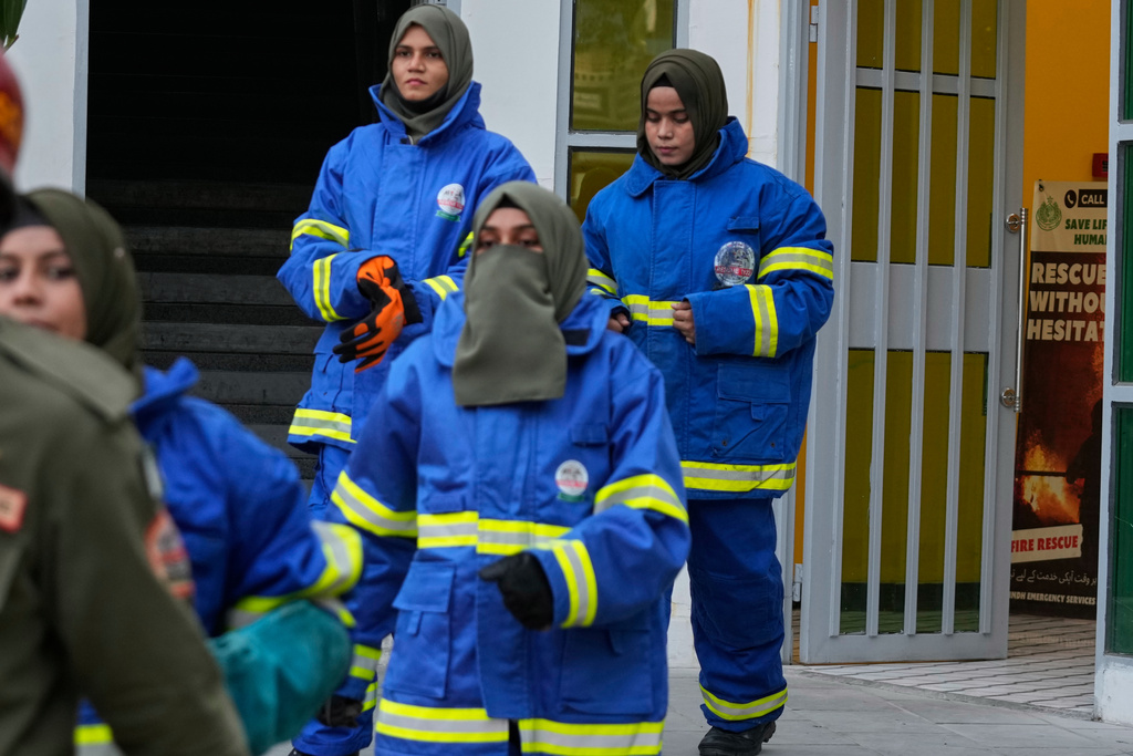 Female firefighter Syeda Masooma Zaidi, right back, arrives with her team members to attend a routine training session, at the compound of their office in Karachi, Pakistan, Friday, Oct. 10, 2025. (AP Photo/Fareed Khan)