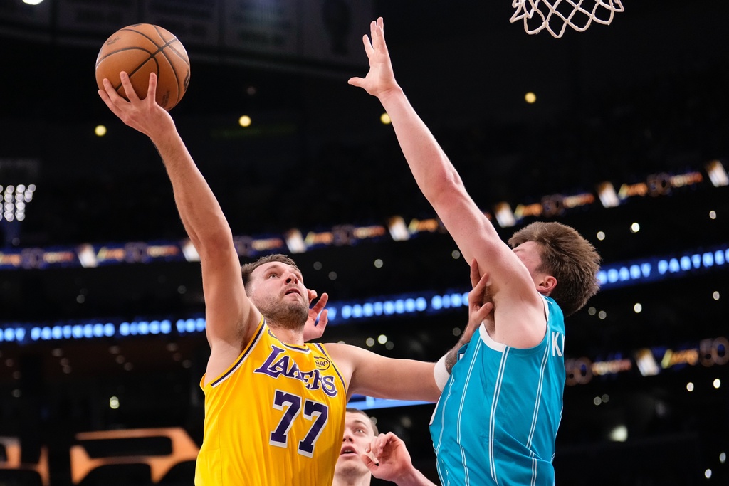 Los Angeles Lakers guard Luka Doncic, left, shoots as Charlotte Hornets guard Kon Knueppel defends during the first half of an NBA basketball game Thursday, Jan. 15, 2026, in Los Angeles. (AP Photo/Mark J. Terrill)