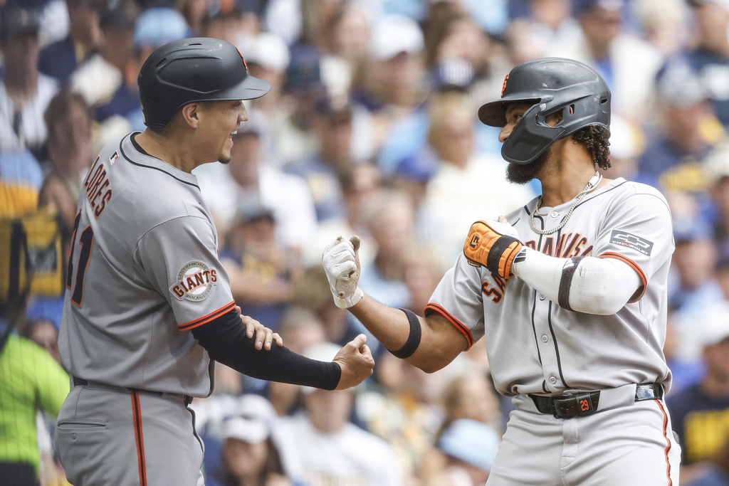 San Francisco Giants' Luis Matos, right, reacts with Wilmer Flores after his two-run home run during the second inning of a baseball game against the Milwaukee Brewers, Sunday, Aug. 24, 2025, in Milwaukee. (AP Photo/Jeffrey Phelps)