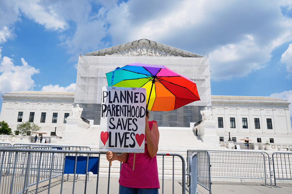 FILE - A protester stands outside of the Supreme Court, June 26, 2025, in Washington. (AP Photo/Mariam Zuhaib, File)