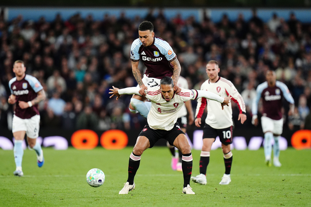 Liverpool's Virgil van Dijk, front, tries to block Aston Villa's Morgan Rogers from the ball during the English Premier League soccer match between Aston Villa and Liverpool in Birmingham, England, Friday, May 15, 2026. (Jacob King/PA via AP)