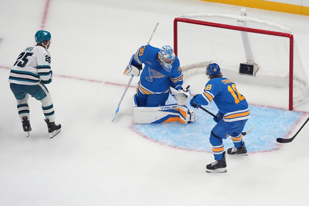 San Jose Sharks' Darnell Nurse (25) scores the game-winning goal past St. Louis Blues goaltender Joel Hofer (30) and Robert Thomas (18) in overtime of an NHL hockey game Thursday, Oct. 8, 2026, in St. Louis. (AP Photo/Jeff Roberson)