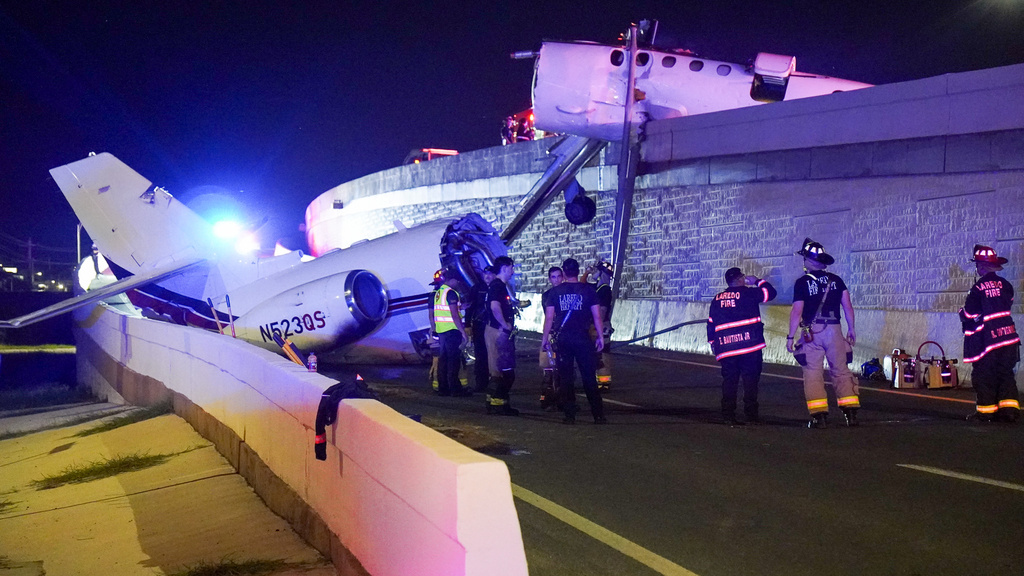 Emergency personnel work near the wreckage of a business jet on Loop 20 near the Clark Boulevard exit in Laredo, Texas, on Tuesday, June 16, 2026. (Jose De La Rosa/The Laredo Morning Times via AP)