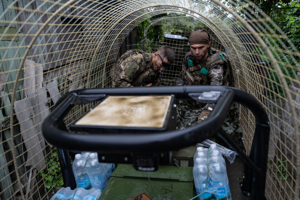 In this photo provided by Ukraine's 93rd Kholodnyi Yar Separate Mechanized Brigade press service, a Ukrainian serviceman unloads a ground drone that carries ammunition, water, and provisions in the frontline town of Druzhkivka, Donetsk region, Ukraine Friday, July 10, 2026. (Iryna Rybakova/Ukraine's 93rd Mechanized Brigade via AP)