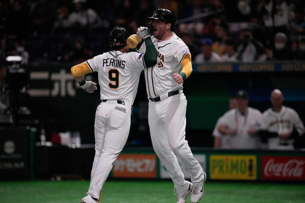 Australia's catcher Robbie Perkins, left, celebrates with Australia's Rixon Wingrove after hits a two-run home run against Taiwan in the fifth inning of a World Baseball Classic game in Tokyo, Thursday, March 5, 2026. (AP Photo/Louise Delmotte)