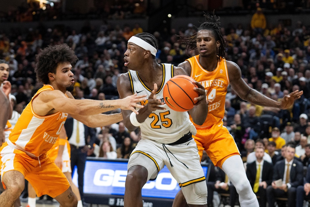 Missouri's Mark Mitchell (25) passes between Tennessee's Ja'kobi Gillespie, left, and Felix Okpara, right, during the second half of an NCAA basketball game Tuesday, Feb. 24, 2026, in Columbia, Mo. (AP Photo/L.G. Patterson)