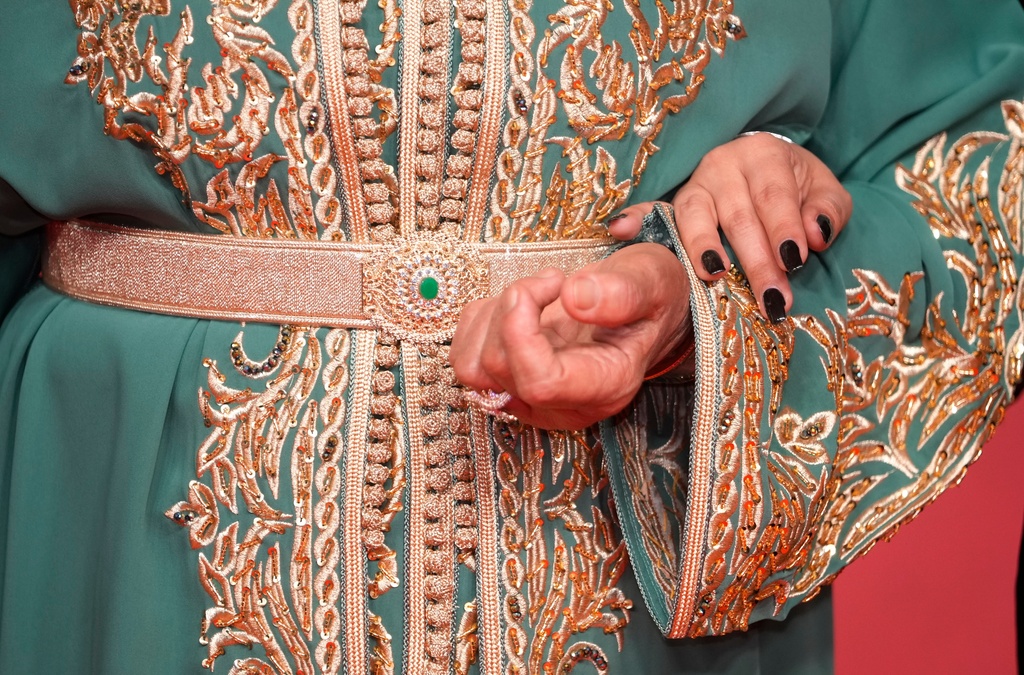 Moroccan actress Fatima Hernadi, also known as Raouia, holds her daughter, while wearing a caftan, as they poses for a photo on the red carpet during the opening ceremony of the 22nd Marrakech Film Festival, in Morocco, Friday, Nov. 28, 2025. (AP Photo/Mosa'ab Elshamy)