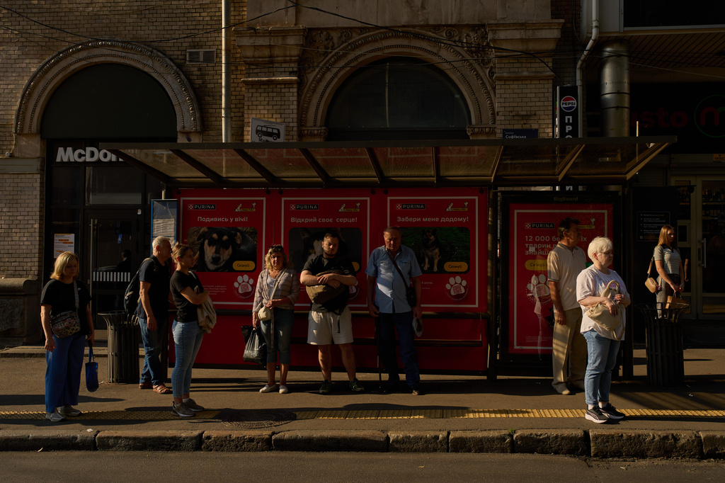 Commuters observe a daily nationwide minute of silence in memory of soldiers killed in the war with Russia, as they wait for a bus in Kyiv, Friday, Sept. 4, 2026. (AP Photo/Francisco Seco)
