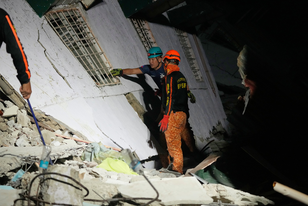 Rescuers check for survivors from the ruins of a collapsed building, Wednesday, Oct. 1, 2025 after a strong earthquake struck Bogo city, Cebu Province, Central Philippines. (AP Photo/Aaron Favila)