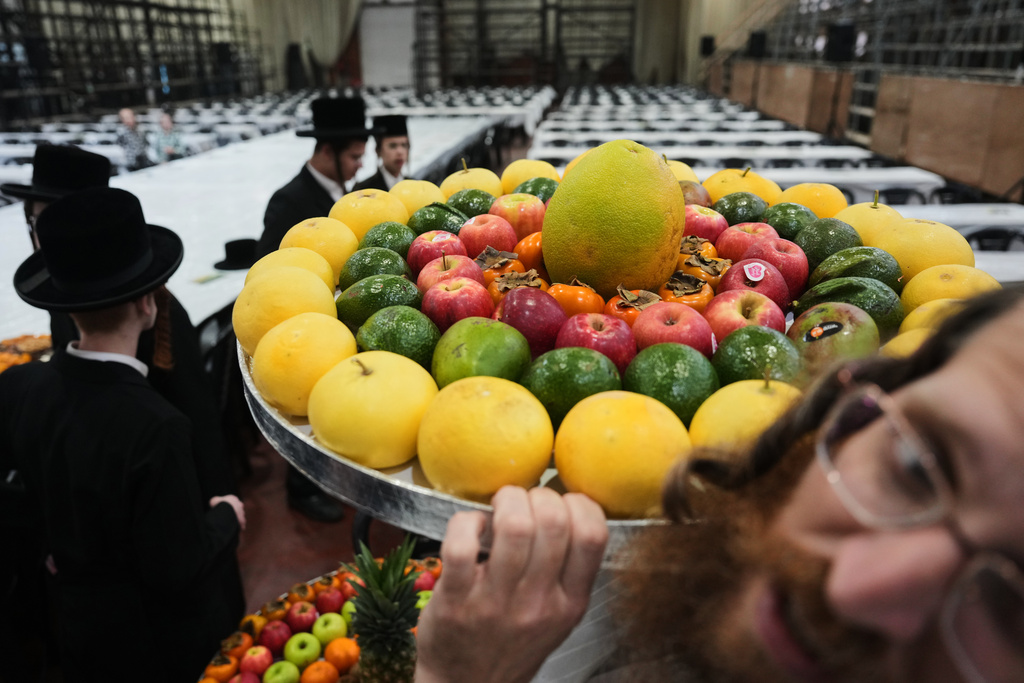 Ultra-Orthodox Jews from the Sanz Hasidic dynasty prepare a table with fruit to celebrate the Jewish holiday of Tu Bishvat, the "New Year of the Trees," in Netanya, Israel, Monday, Feb. 2, 2026. (AP Photo/Ariel Schalit)