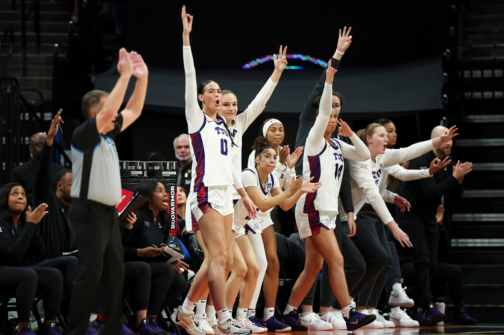 The TCU bench celebrate after guard Olivia Miles, not shown, makes a 3-pointer during the second half in the Sweet 16 of the NCAA college basketball tournament against Virginia Saturday, March 28, 2026, in Sacramento, Calif. (AP Photo/Sara Nevis)
