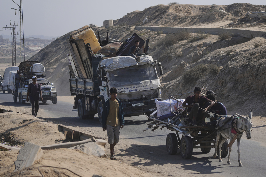 Displaced Palestinians fleeing northern Gaza carry their belongings along the coastal road toward southern Gaza, Tuesday, Sept. 9, 2025, after the Israeli army issued evacuation orders from Gaza City. (AP Photo/Jehad Alshrafi)