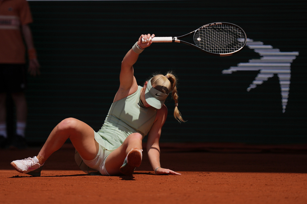 Emerson Jones of Australia falls down as she plays against Iga Swiatek of Poland during their first round women's singles tennis match at the French Open tennis tournament in Paris, Monday, May 25, 2026. (AP Photo/Thibault Camus)