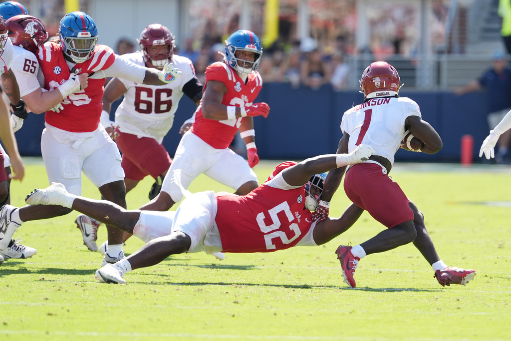Mississippi defensive tackle Will Echoles (52) reaches for Washington State running back Angel Johnson (1) during the second half of an NCAA college football game, Saturday, Oct. 11, 2025, in Oxford, Miss. (AP Photo/Rogelio V. Solis)