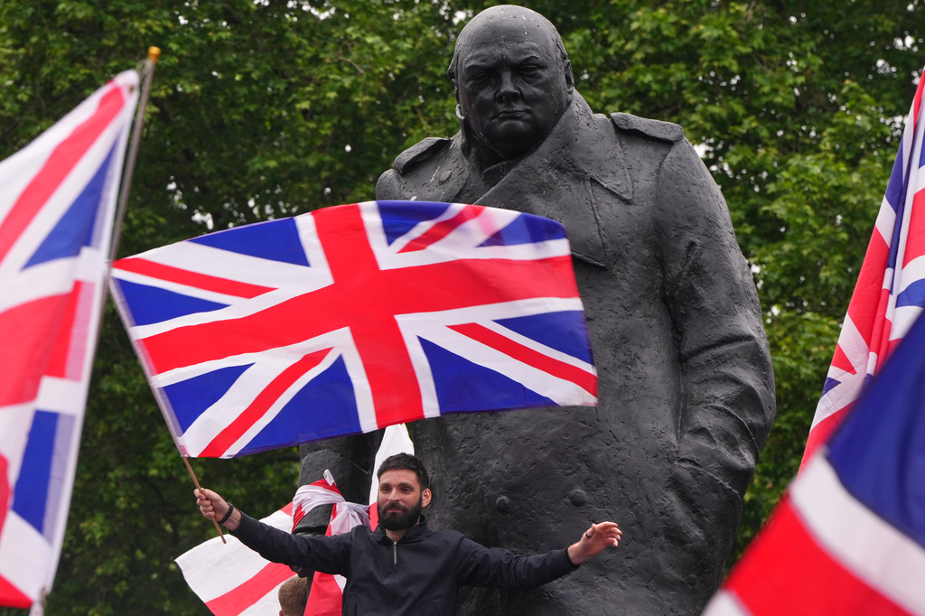 Protesters wave flags at the Winston Churchill statue during the Unite the Kingdom march in London, Saturday, May 16, 2026.(AP Photo/Kirsty Wigglesworth)