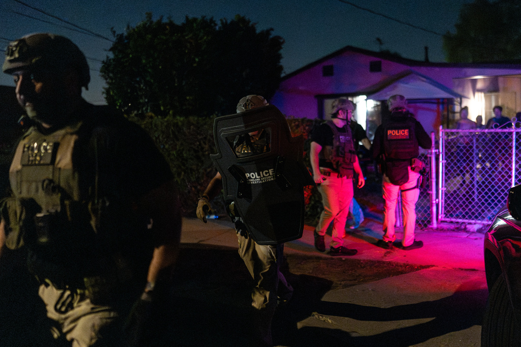 Homeland Security Investigations officers leave a home after arresting a suspect accused of illegally registering to vote during a federal operation in Commerce, Calif., Monday, Oct. 19, 2026. (AP Photo/Jae C. Hong)