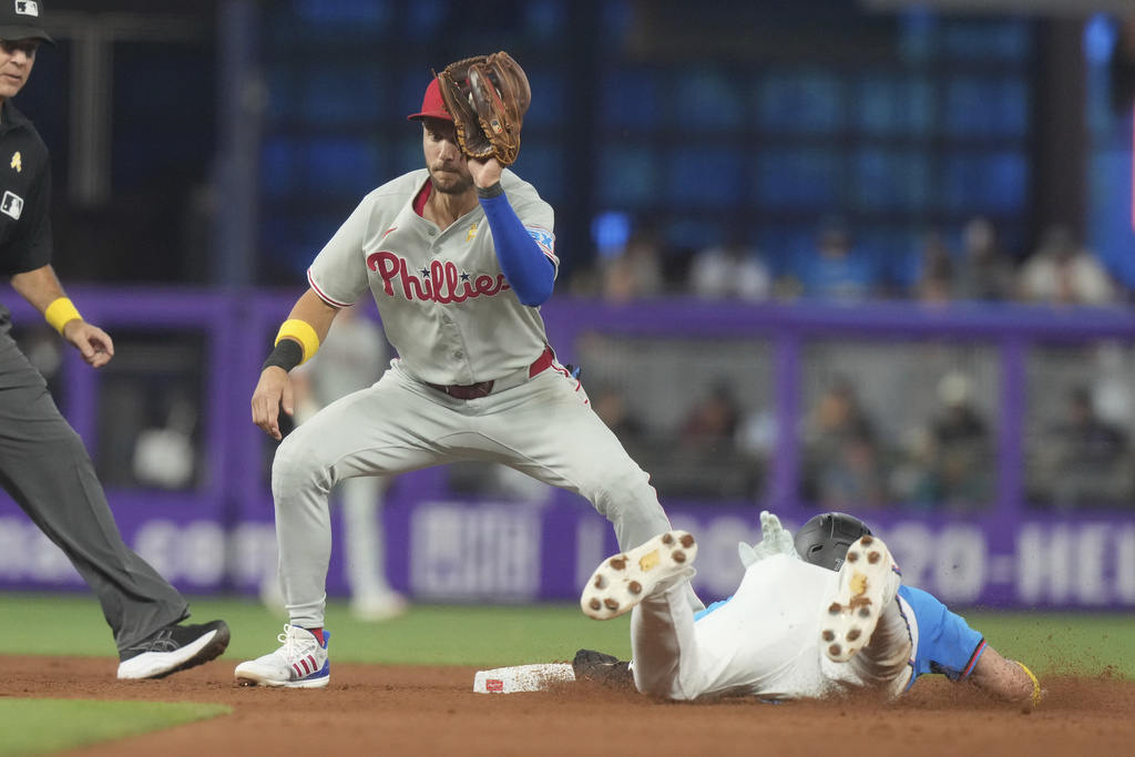 Philadelphia Phillies short stop Trea Turner is late with the tag as Miami Marlins' Troy Johnston steals second base during the sixth inning of a baseball game Sunday, Sept. 7, 2025, in Miami. (AP Photo/Marta Lavandier)