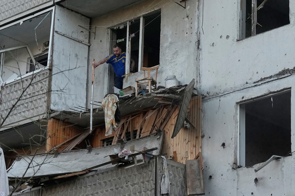 A man clears debris in his apartment building damaged after a Russian missile strike that hit in Kyiv, Ukraine, Tuesday, June 2, 2026. (AP Photo/Efrem Lukatsky)