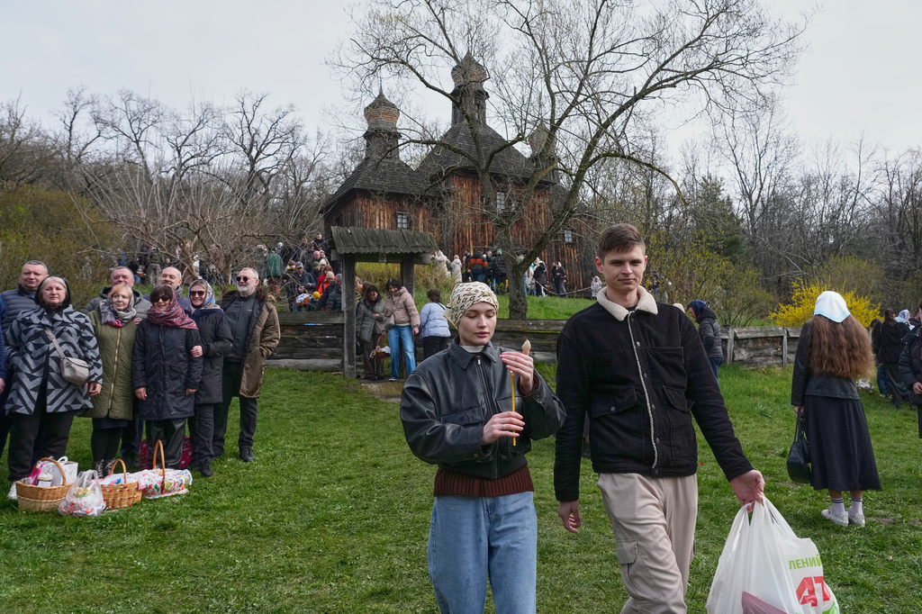 People carry candles and Easter baskets as they leave an old church to mark Orthodox Easter, in Pyrohiv, close to Kyiv, Ukraine, Sunday, April 12, 2026. (AP Photo/Efrem Lukatsky)