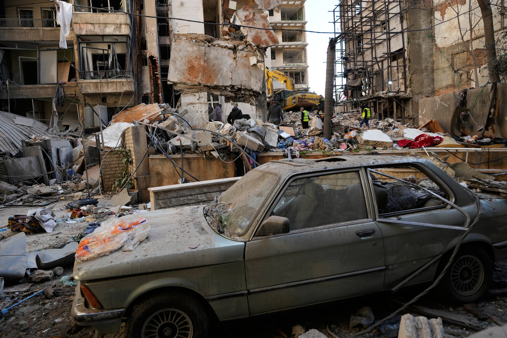A damaged car is seen in an area as Lebanese civil defense workers search for victims in the rubble of a building destroyed in an Israeli airstrike a day earlier in central Beirut, Lebanon, Thursday, April 9, 2026. (AP Photo/Hussein Malla)