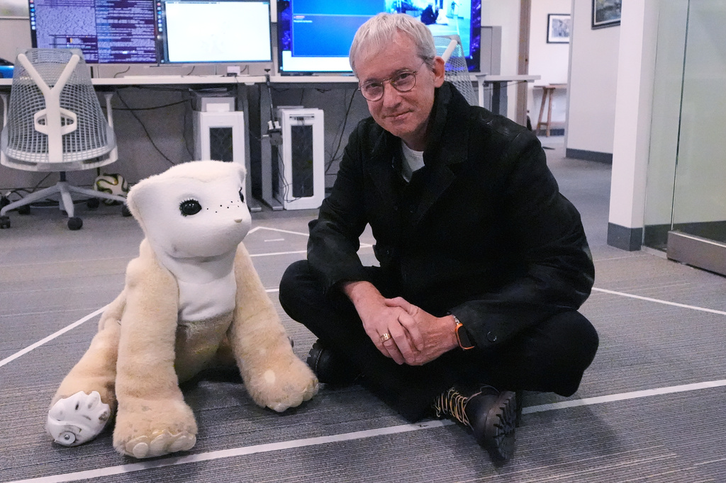 Colin Angle, co-founder and former CEO of Roomba vacuum maker, poses with Familiar, a prototype AI pet robot, at his Massachusetts-based startup Familiar Machines & Magic, Wednesday, April 29, 2026, in Woburn, Mass. (AP Photo/Charles Krupa)