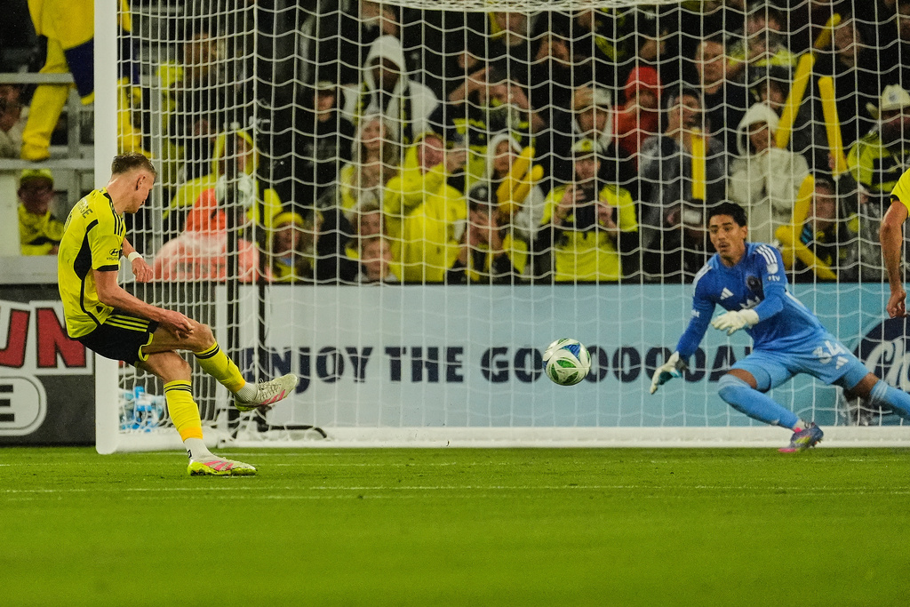 Nashville SC forward Sam Surridge, left, scores a goal on a penalty kick past Inter Miami goalkeeper Rocco Ríos Novo (34) during the first half of Game 2 in the first round of MLS soccer Eastern Conference playoff Saturday, Nov. 1, 2025, in Nashville, Tenn. (AP Photo/George Walker IV)