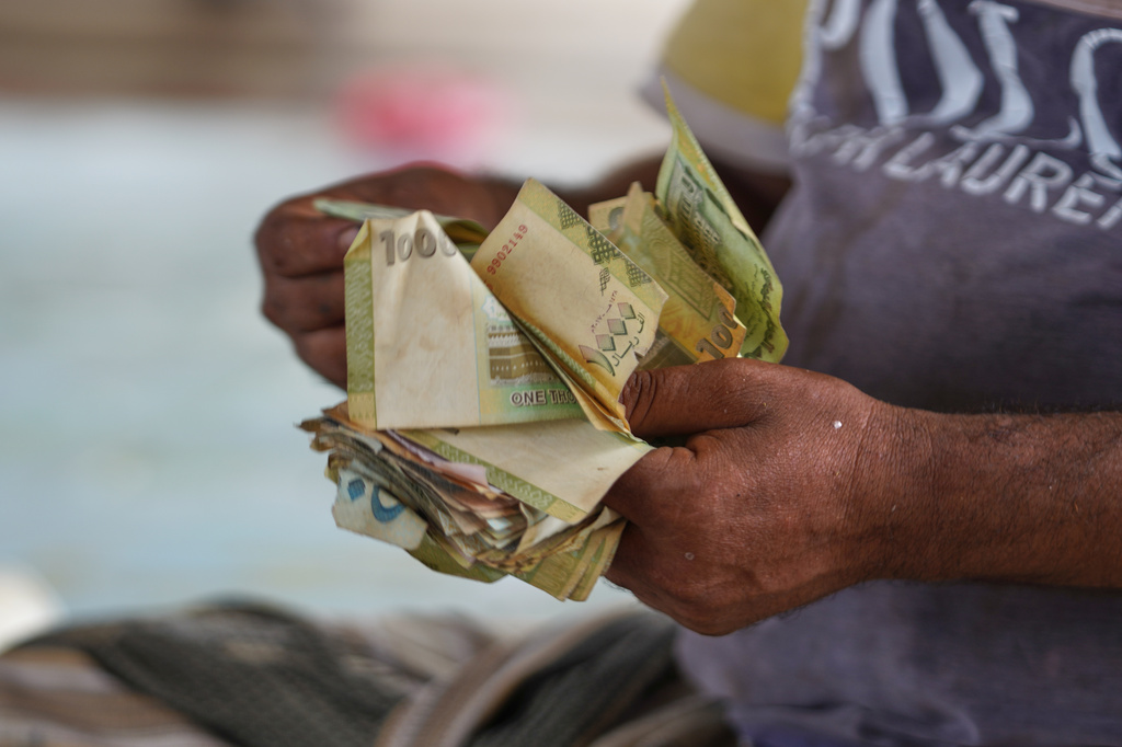 A man counts Yemeni currency at a gas station in Aden, Yemen, Tuesday, Sept. 15, 2026. (AP Photo/Abdulnasser Alseddik)