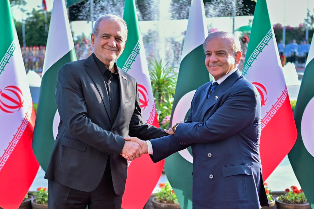 In this photo released by Pakistan Prime Minister Office, Iran's President Masoud Pezeshkian, left, shakes hands with Pakistan's Prime Minister Shehbaz Sharif during a welcome ceremony in Islamabad, Pakistan, on Tuesday, June 23, 2026. (Pakistan Prime Minister Office via AP)