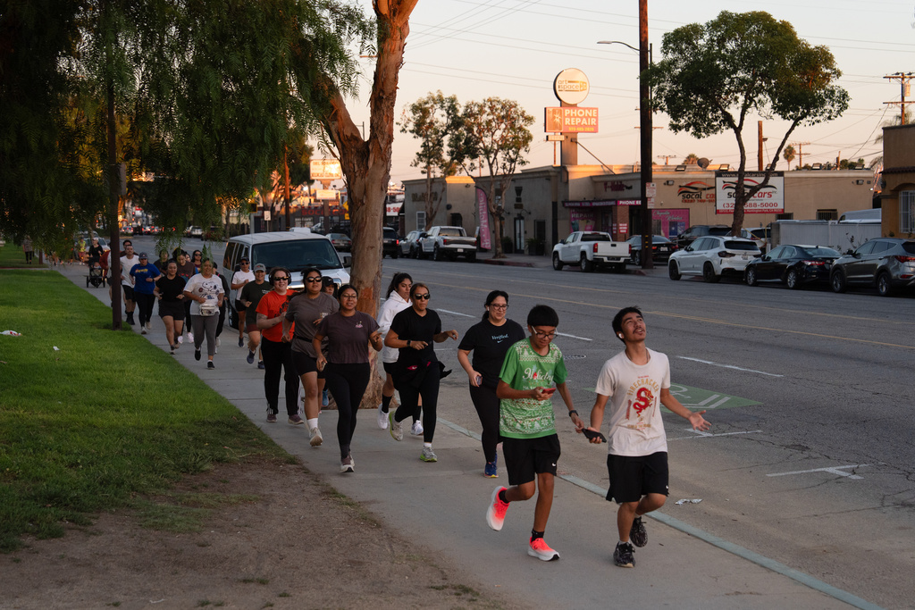 Members of the Huntington Park Run Club jog through a neighborhood in Huntington Park, Calif., Sept. 24, 2025. (AP Photo/Jae C. Hong)