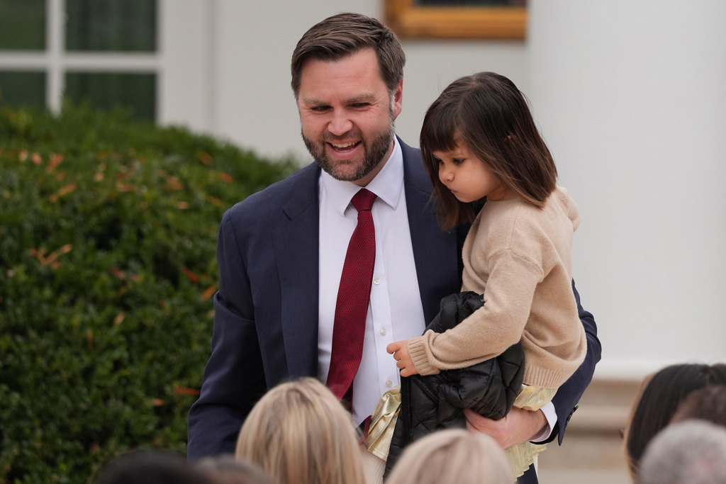 Vice President JD Vance holding his daughter Mirabel, as they take their seat for pardoning ceremony for the national Thanksgiving turkeys Waddle and Gobble in the Rose Garden of the White House, Tuesday, Nov. 25, 2025, in Washington. (AP Photo/Evan Vucci)